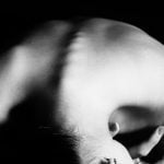 A black and white picture of the back of a woman with her bones visible.