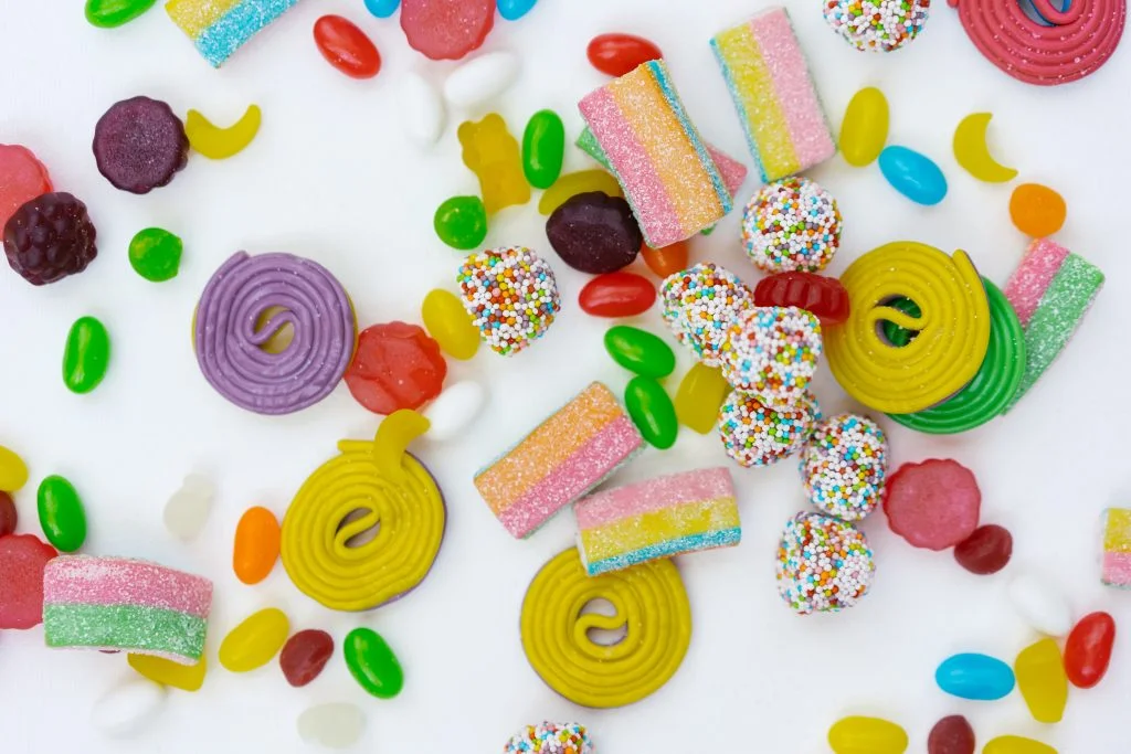 Colorful candy and measuring tape with a white background.