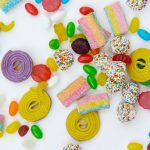 Colorful candy and measuring tape with a white background.