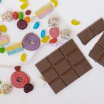 Candy, measuring tape, and chocolate bars with a white background.