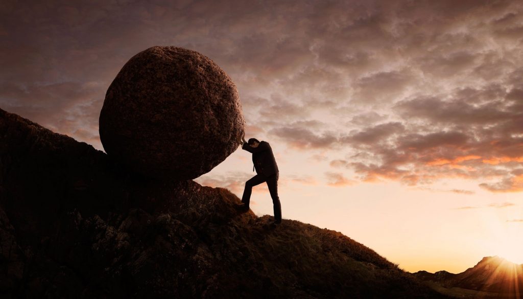 man holding up a rock that symbolizes stress