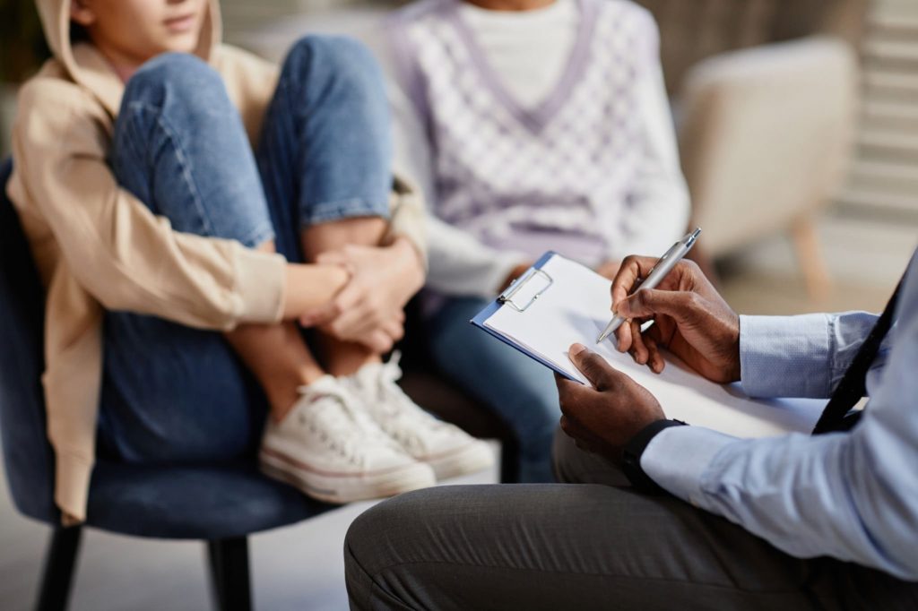 a person talking to a mental health specialist with someone else in the background