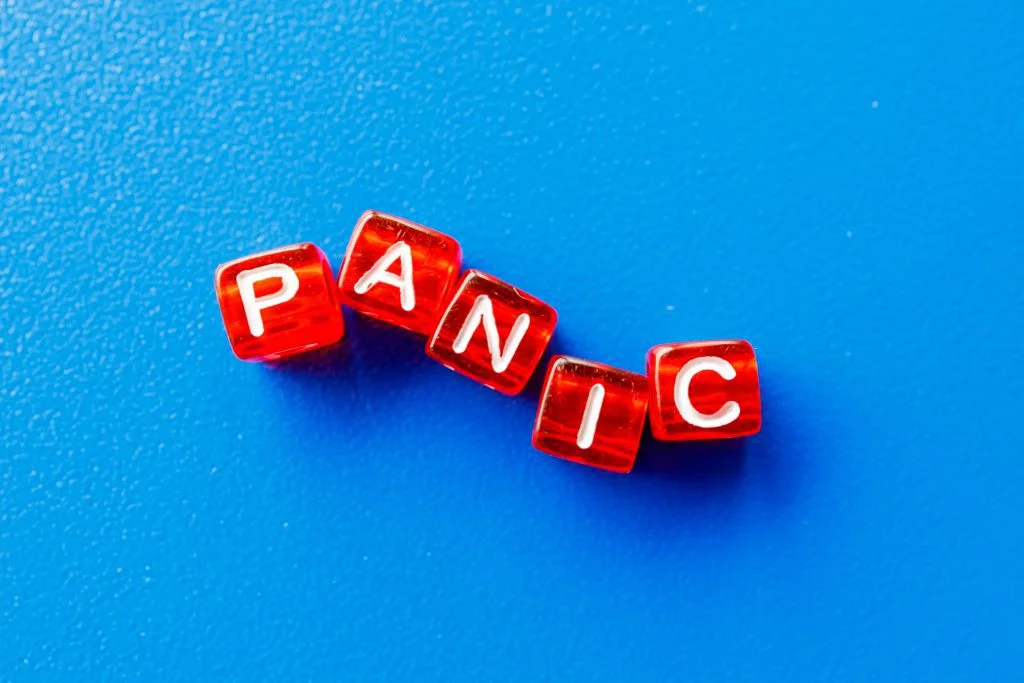 Dice cubes in red that spell the word 'panic' with a blue background.