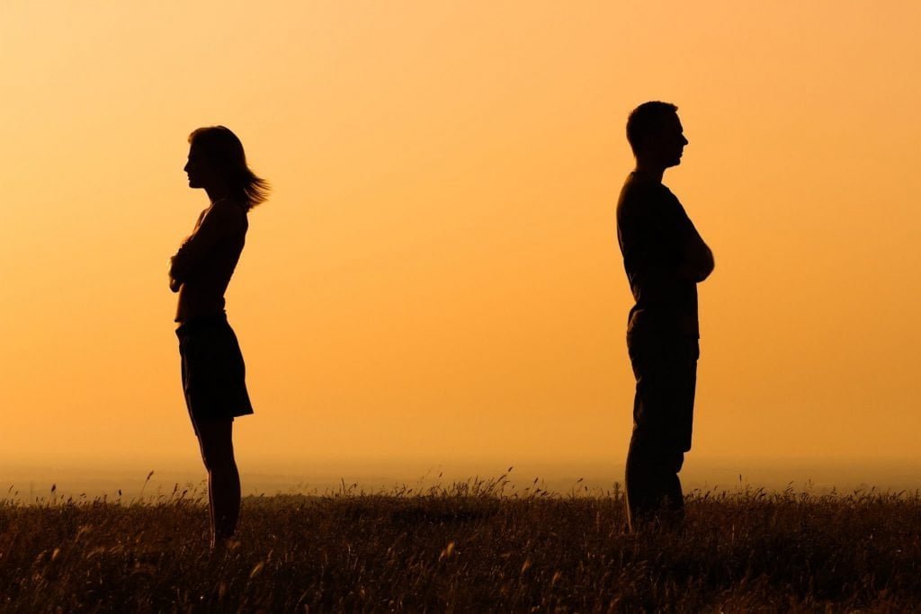 two people avoiding each other with their backs turned away